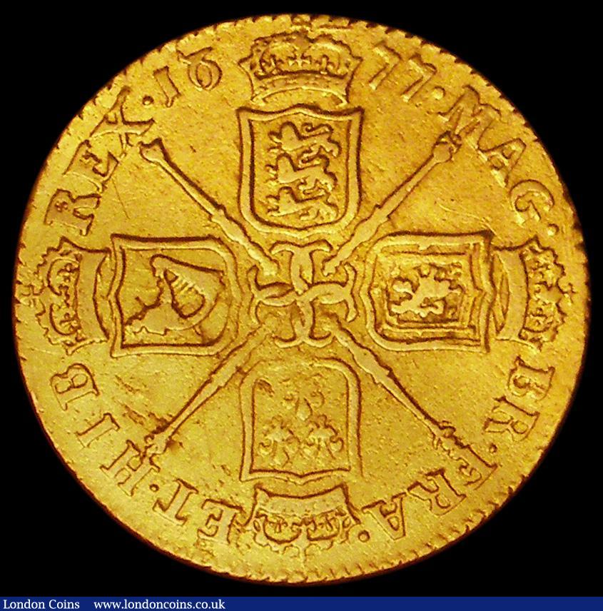 London Coins : A162 : Lot 1752 : Guinea 1677 as S.3344 the first 6 of the date with an extra line showing at the top left of the curv...