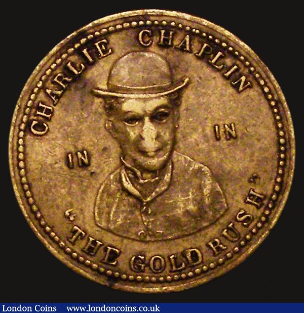Advertising Token Charlie Chaplin 'The Goldrush' 1926 Manchester Gaiety Theatre, 26mm diameter in brass Obverse: CHARLIE CHAPLIN IN IN 'THE GOLDRUSH' Reverse: GAIETY THEATRE MANCHESTER COMMENCING 11th JANUARY 1926 4 WEEKS VF with some toning spots : Misc Items : Auction 172 : Lot 803